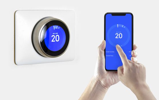 A person using a smart phone application cooling down the room temperature with a wireless smart thermostat on a white background.