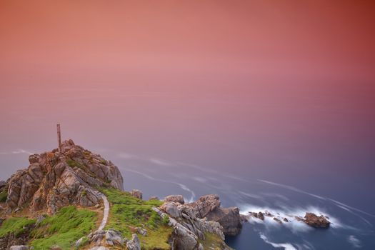 Rocky cliff at sea with pink gradient