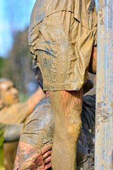 Sportsman's legs in dirty sportswear climbing. Close up. Unrecognizable