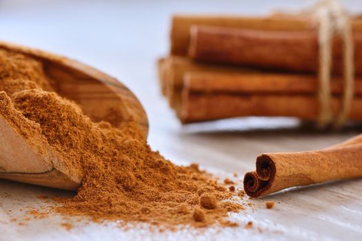Close-up of powdered cinnamon with sticks on table