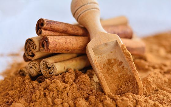 Close-up of powdered cinnamon with sticks on table