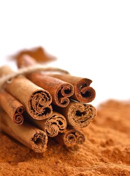 Close-up of powdered cinnamon with sticks isolated background