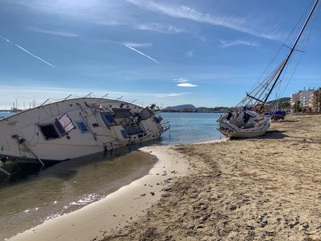 Several boats stranded on the beach after a storm. On a sunny day with few clouds.