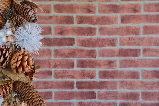 Close up of decorative Christmas cones at left side against of brick wall