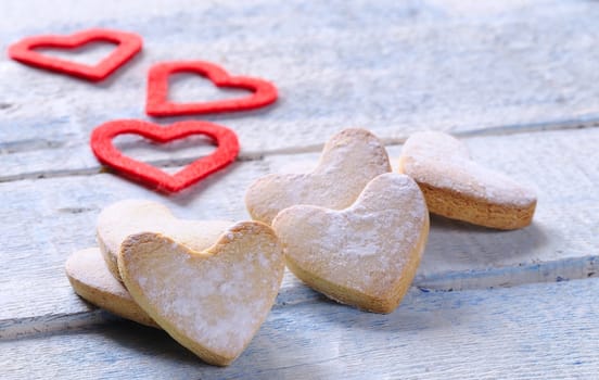 Homemade cookies for valentines day over wooden table