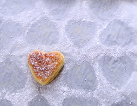 Heart-shaped puff pastry for valentines day over wooden table