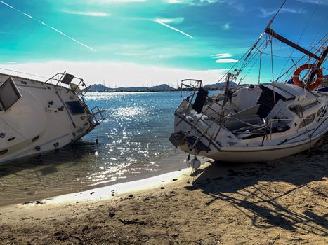 Several boats stranded on the beach after a storm. On a sunny day with few clouds.