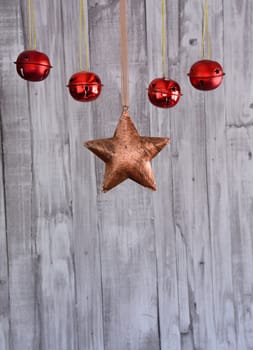 Close up of Christmas star and red balls hanging on the rope against wooden background