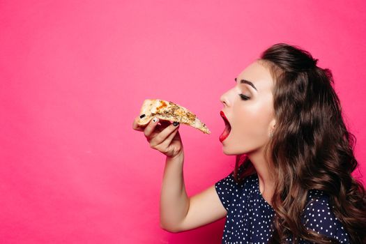 Side view of pretty girl with long wavy hair eating delicious hot slice of pizza over bright magenta background. Isolate. Copyspace.