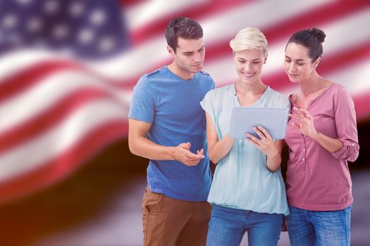 Group portrait of happy colleagues using tablet against composite image of digitally generated united states national flag