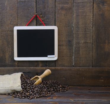 Coffee beans with blackboard on a wooden table.