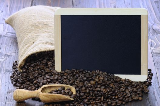 Coffee beans with blackboard on a wooden table.