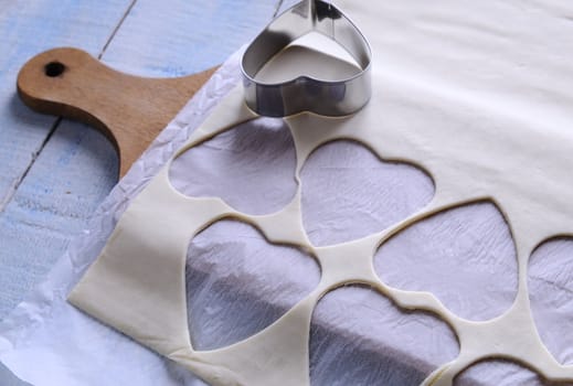 Heart-shaped puff pastry for valentines day over wooden table