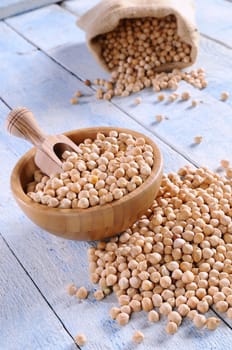 Tasty chickpeas prepared for cooking on wooden table.