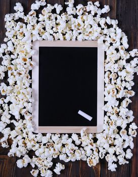 Popcorn and blackboard on a wooden table