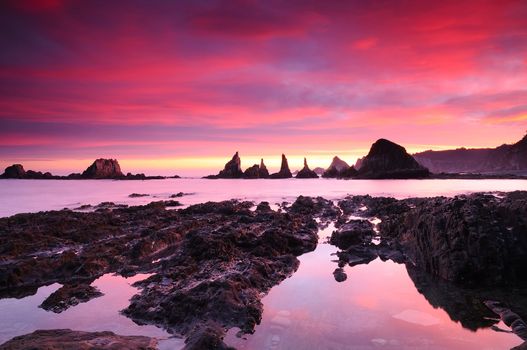 Picturesque seascape. Rocky mountains, colorful sunset.