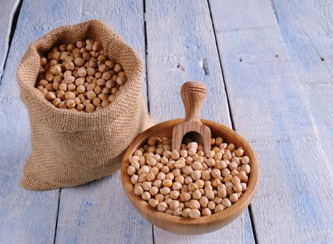 Tasty chickpeas prepared for cooking on wooden table.