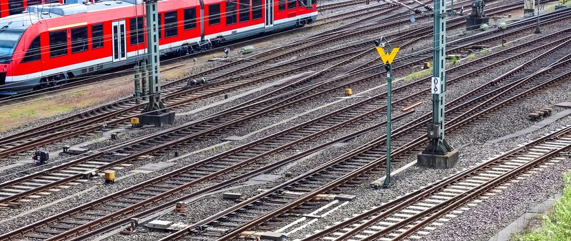 Multiple railroad tracks with junctions at a railway station in a perspective view