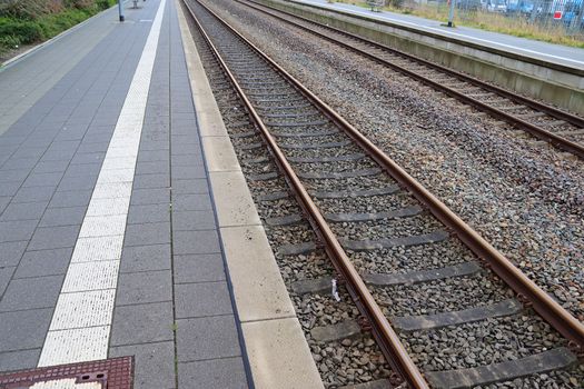 Multiple railroad tracks with junctions at a railway station in a perspective view