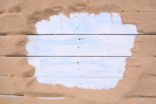 Blue wood surrounded by sand on the beach with space for text entry