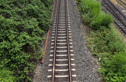 Multiple railroad tracks with junctions at a railway station in a perspective view