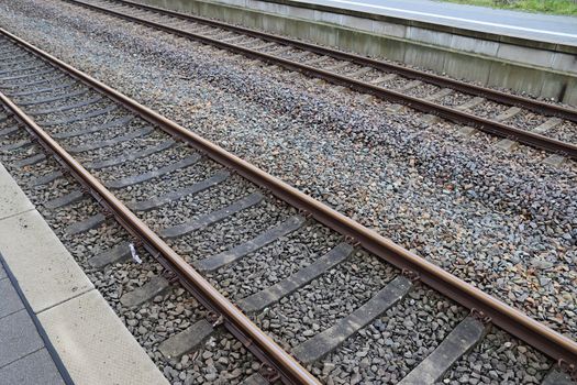 Multiple railroad tracks with junctions at a railway station in a perspective view