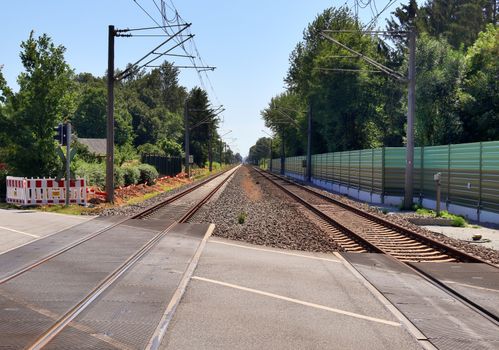 Multiple railroad tracks with junctions at a railway station in a perspective view