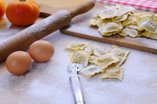 Uncooked vareniki on table covered with flour.Eggs, rolling pin.