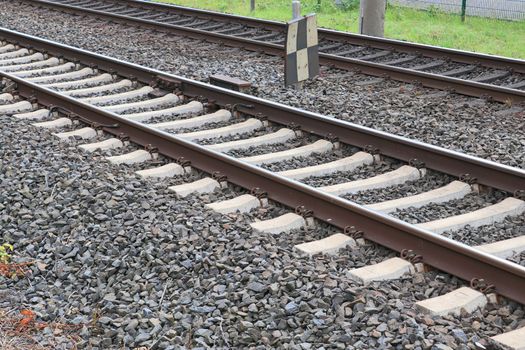 Multiple railroad tracks with junctions at a railway station in a perspective view