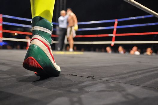 View of a ring in a boxing match with boxer feet in the foreground