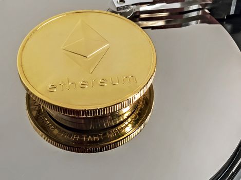 Physical Coin Cryptocurrency Ethereum ETH Gold Plated Bitcoin in laptop hard disk server. Crypto currency blockchain Ethereum Coin virtual money concept isolated on white background.