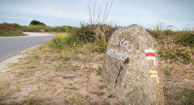 Petit Fradets road painted on a large stone indicating a hiking path by the sea on the island of Yeu