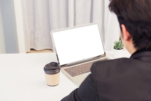 Work from home, Asian young businessman smile wearing suit video conference call or facetime by laptop computer sitting and listening to teammates explained on desk at home office