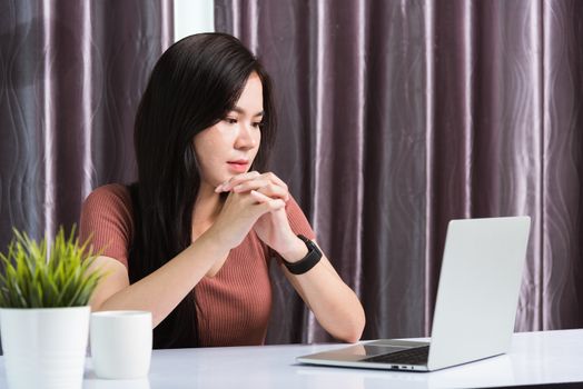 Work from home, Smiling Happy Asian business young beautiful woman sitting on desk workspace video call conferencing with team by webcam laptop computer technology at home office