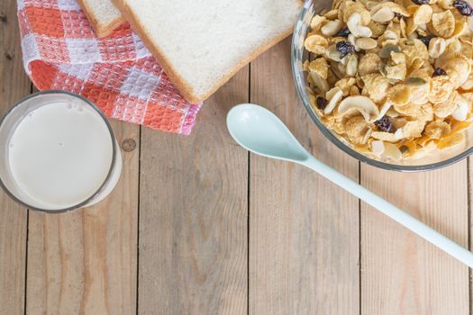 Breakfast in morning, corn flakes,bread,milk on wooden table,copy space