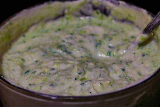 Traditional greek dip sauce or dressing tzatziki prepared with grated cucumber sour cream yogurt olive oil and fresh dill..