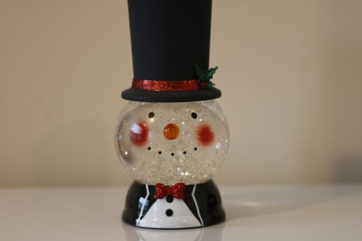 Christmas snow globe with knitting clothes on blurred background. Space for text.