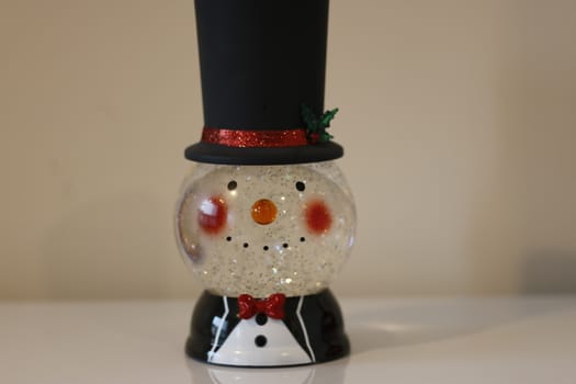 Christmas snow globe with knitting clothes on blurred background. Space for text.