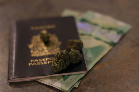 Legalization of cannabis for recreational use in Canada. The national Canadian flag made of dry weed against the brown wooden background. The image symbolizing the country's legal marijuana laws.