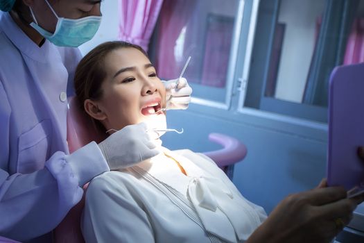 A beautiful woman giving the dentist a dental and oral examination For healthy mouth and teeth