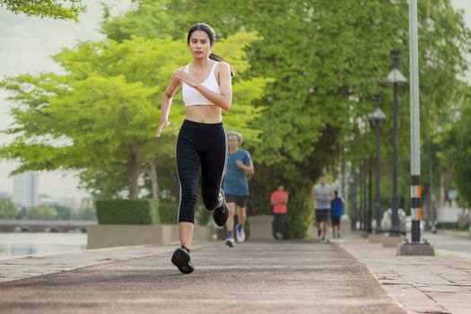 Portrait of beautiful woman running in the park in early morning. Healthy concept