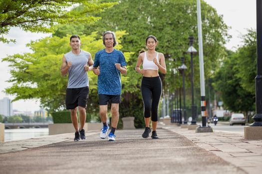 Family exercising and jogging together in the outdoor garden. Healthy family