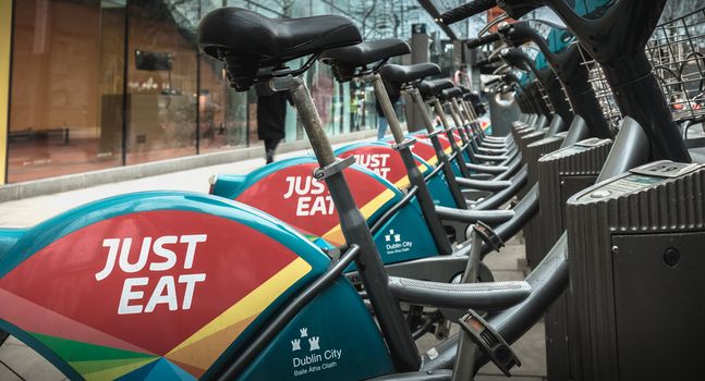 Dublin, Ireland - February 11, 2019: Detail of a shared public bike station Just Eat dublinbikes in the city center on a winter day