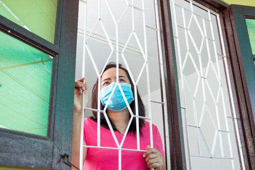 Corona virus (COVID-19), During detention at home Masked woman Feeling sad and lonely alone in the house Sometimes she uses her phone to make video calls to friends.