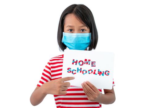 Coronaryvirus and Education Concepts, The girl wearing a mask holding a paper with a message "Home Schooling" To encourage everyone to work together to teach children at home.
