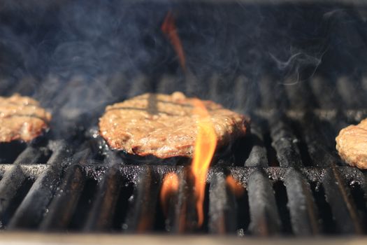 Burgers. Hamburgers being flame broiled on the gas grill