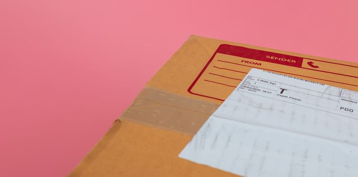Parcel boxes are shipped by shipping companies on a bright pink background.