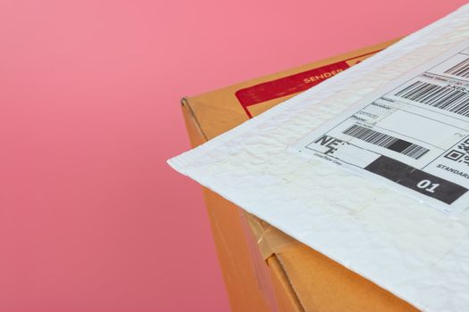 Parcel boxes are shipped by shipping companies on a bright pink background.