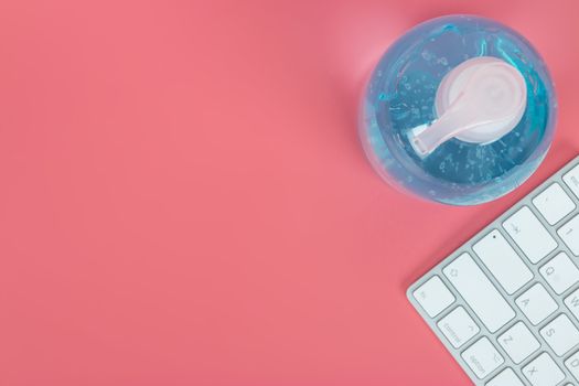 Flat lay, top view office table desk. Workspace with keyboard and mouse on pink background.