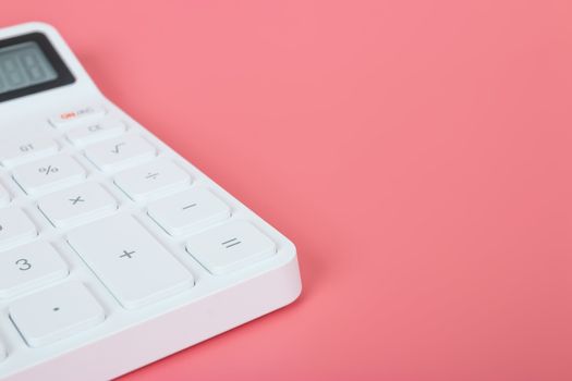 White calculator on a bright pink background, marketing and financial concepts